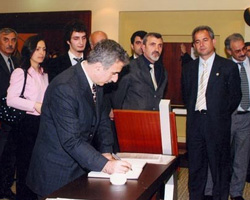 Dönemin Çanakkale Valisi Süleyman Kamçı, Salih Cengiz'in anı defterini imzalarken.